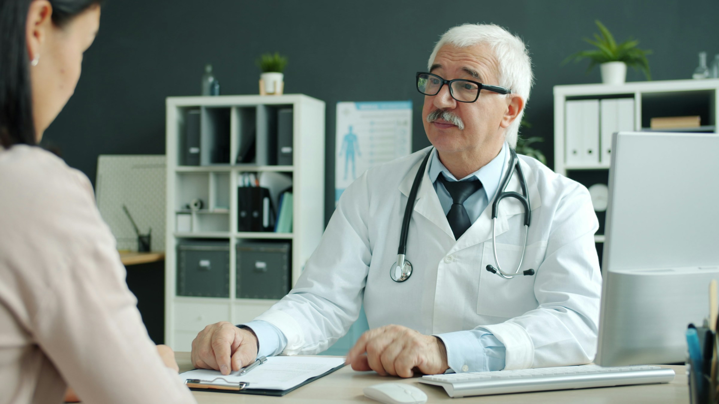 A woman discussing her health with a physician during an office consultation